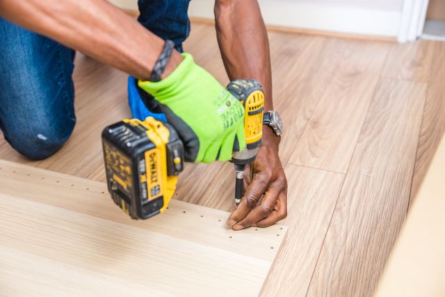 person drilling screws into wood
